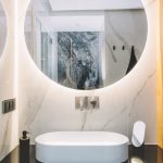 Modern sink and round mirror with led light in a luxury bathroom